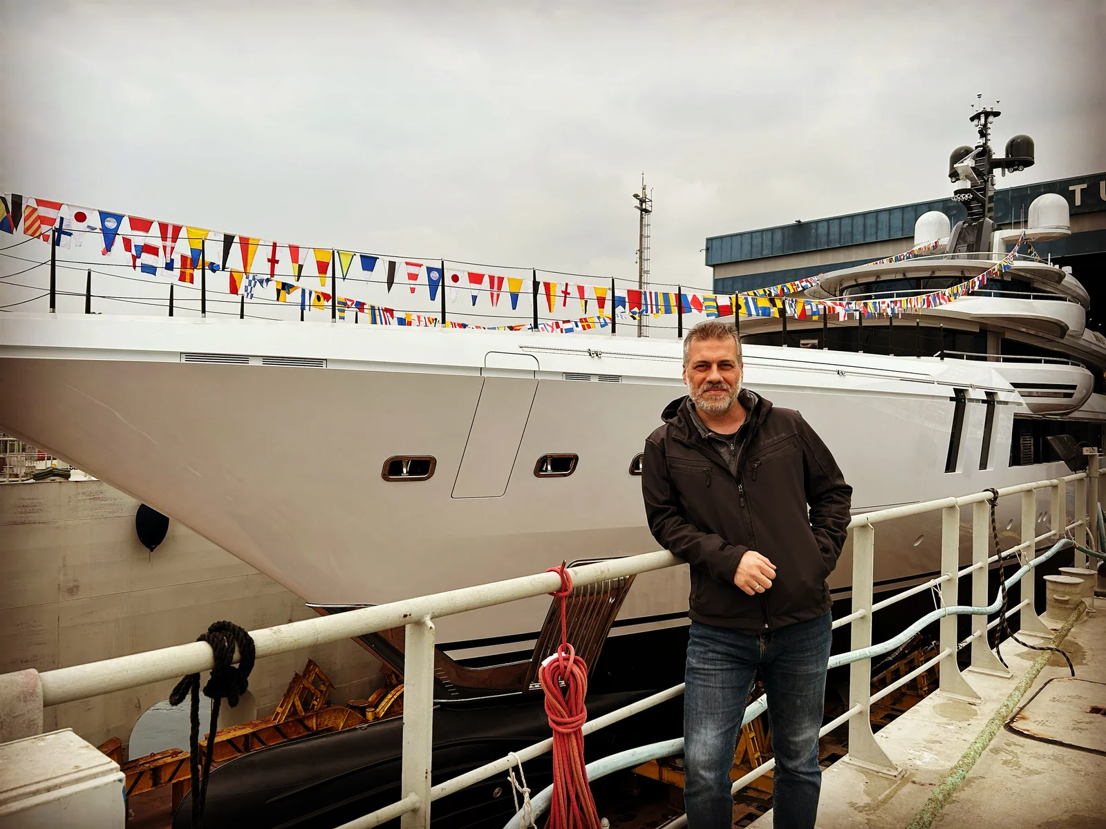 Kerim Tapkan at a shipyard, standing beside a yacht.